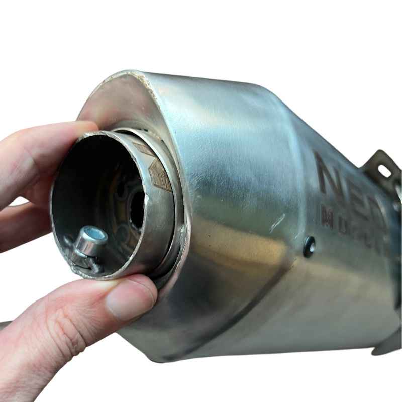 Close-up of Neo Muscle stainless steel DB Killer being inserted into Yamaha XSR155 exhaust muffler, showing quick installation and secure fit.