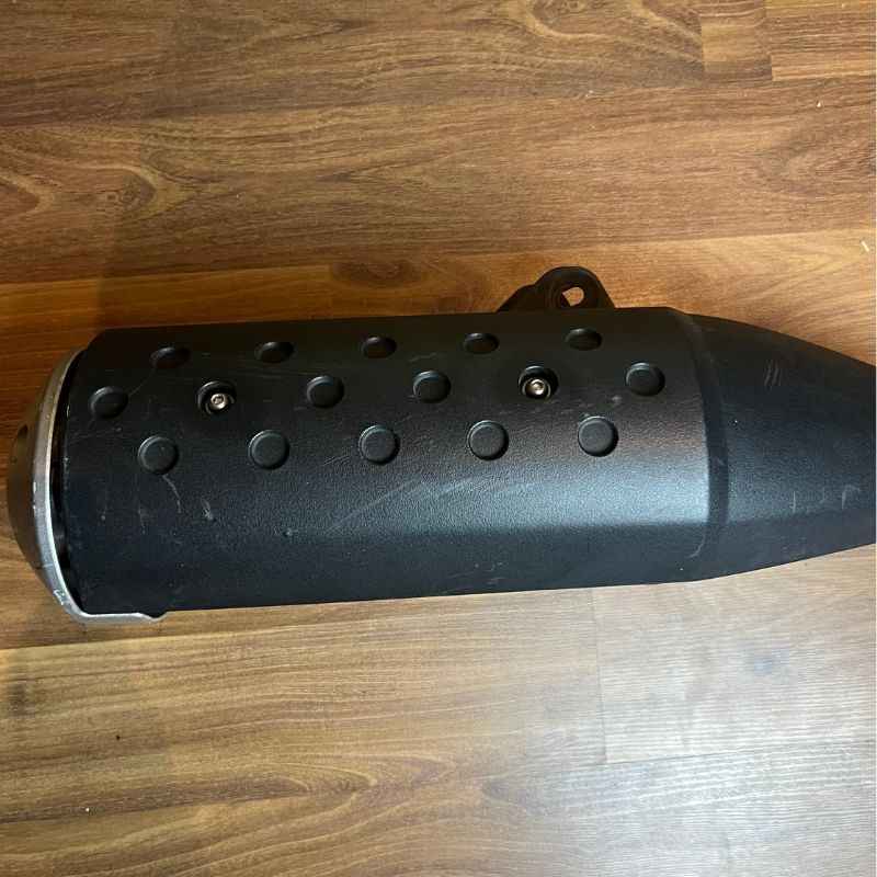 Rear view of the original Yamaha XSR155 OEM exhaust muffler showing the factory mounting bracket and end cap. Genuine Yamaha exhaust removed from the Neo Muscle project motorcycle.
