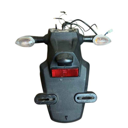 Front view of the original Yamaha XSR155 OEM rear fender assembly with factory turn signals, license plate bracket, reflector, wiring harness and connectors removed from the Neo Muscle project motorcycle.