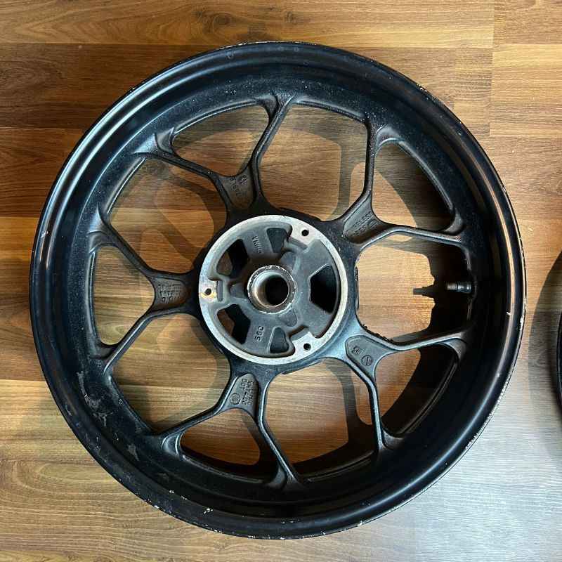 Close-up of the original Yamaha XSR155 OEM wheel hub (velg) removed from the Neo Muscle project motorcycle. Genuine factory wheel component.