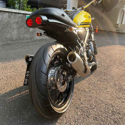 Rear three-quarter view of a custom Yamaha XSR155 featuring Neo Muscle handcrafted café racer bodywork, twin round LED design, custom exhaust system and minimalist styling.